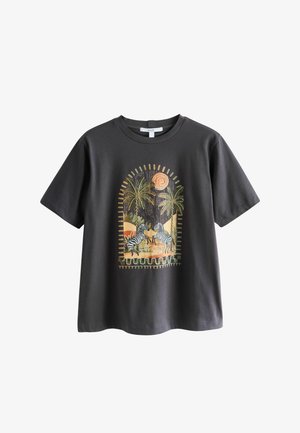 Maglietta grigio scuro con un motivo stampato di zebra e palme in toni terrosi, incorniciata da un bordo ad arco con dettaglio a sole.