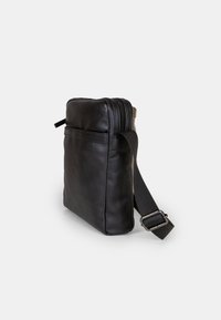 Borsa a tracolla in pelle nera con chiusura a zip, tracolla regolabile e tasca frontale. Texture liscia e forma rettangolare.