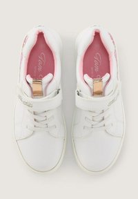 Weiße Sneakers mit einer glatten Textur, ausgestattet mit einem Klettverschluss, rosa Innenfutter und bunten Blumenakzenten an der Seite.