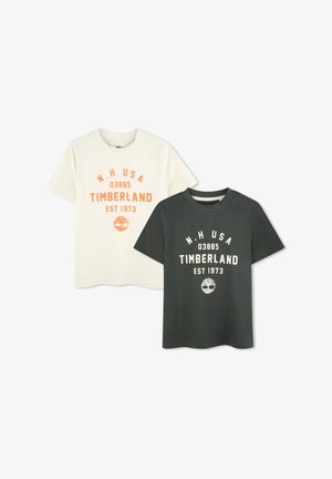 Deux t-shirts en coton : un crème avec impression orange, un vert foncé avec impression blanche. Tous deux présentent des cols ronds et des manches courtes.