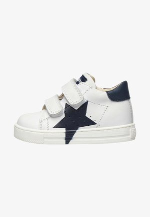 White leather sneaker with navy star design, two Velcro straps, and a textured white rubber sole. Features perforated accents.