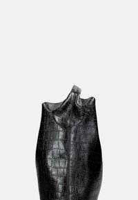 Borsa in pelle nera con motivo coccodrillo, con testa arricciata e chiusura a zip; texture liscia e forma curva, progettata per un uso versatile.