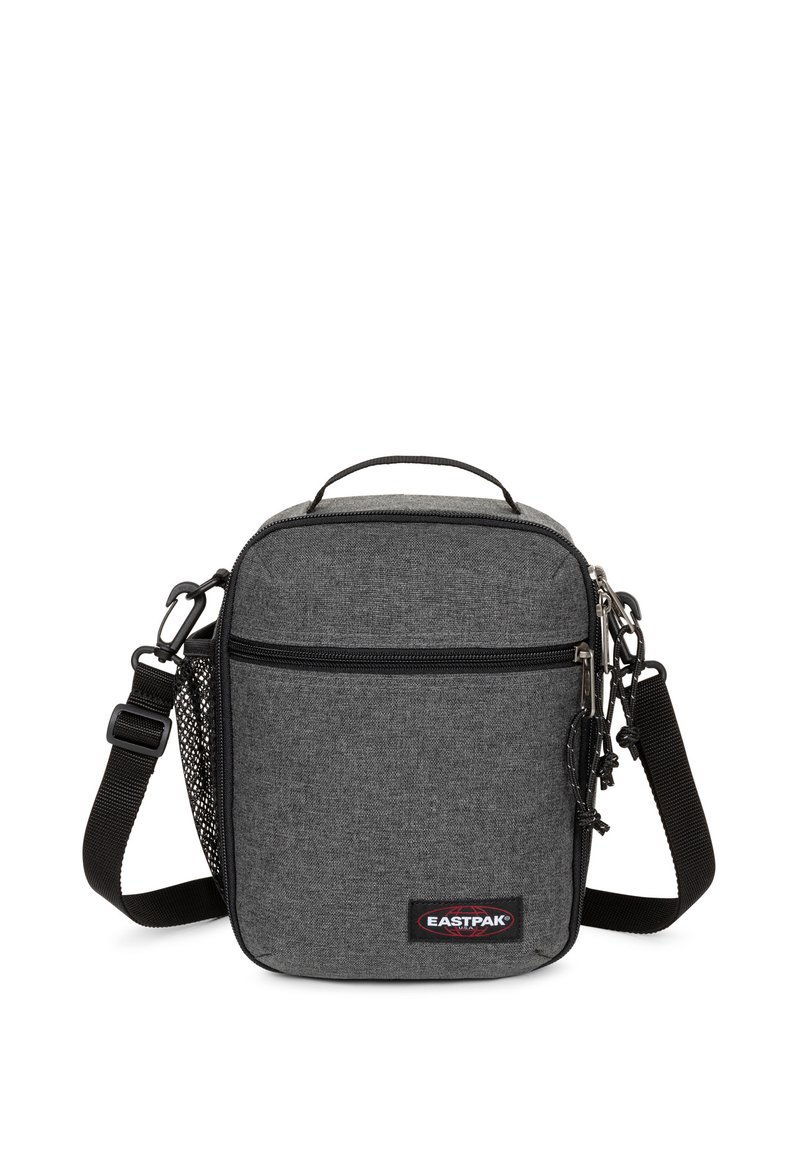 Piccola borsa a tracolla grigia realizzata in tessuto, con chiusura a zip, tracolla regolabile, manico superiore e una tasca laterale in rete. Presenta il logo EASTPAK.