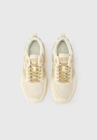 Μπεζ αθλητικά παπούτσια με σχέδιο από σουέτ και δίχτυ, με στρογγυλά κορδόνια, ανάγλυφο λογότυπο στη γλώσσα και υφασμένες σόλες από καουτσούκ.