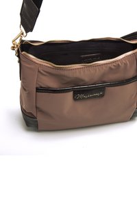 Sac à bandoulière en nylon brun avec une base texturée noire, fermeture éclair dorée et une poche avant avec une plaque logo dorée.