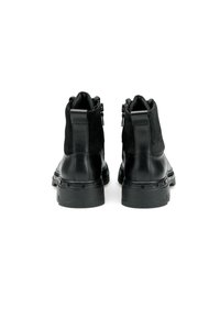 Stivaletti neri con una combinazione di materiali in pelle e camoscio, dotati di suola spessa, cerniere laterali e una texture liscia.