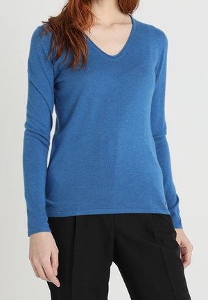 Pull-over en V couleur bleu vif, fabriqué en tissu tricoté doux. Il dispose de manches longues et d'une silhouette ajustée. Agrémenté d'un logo de marque subtil.