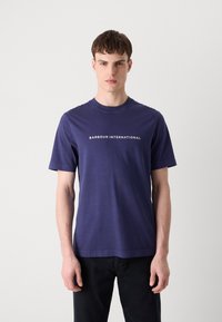 Tricou din bumbac bleumarin, cu mâneci scurte, având un logo alb "BARBOUR INTERNATIONAL" pe piept. Design clasic cu guler tip crew neck.