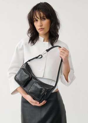 Černá kožená crossbody taška s dvěma předními zipovými kapsami, hladkým povrchem, nastavitelným popruhem a jemnými švy.