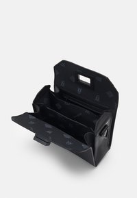 Sac à main en cuir noir ouvert montrant trois compartiments principaux et une poche zippée, avec une doublure en tissu à motifs et une ouverture rectangulaire pour la poignée.