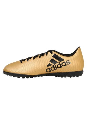Złote syntetyczne buty piłkarskie z teksturowaną cholewką, czarnym logo Adidas i czarną gumową podeszwą z wkrętami dla lepszej przyczepności.