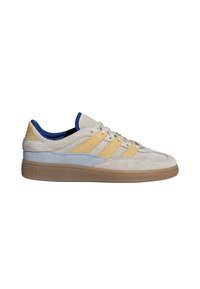 Suede sneakers with a light gray upper, blue and yellow accents, and a rubber sole. Features three stripes and a padded collar.