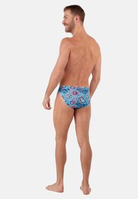Badehosen in Blau mit einem Paisleymuster in Pink und Grün. Hergestellt aus glattem Stoff, mit einem niedrigen Design und elastischem Bund.