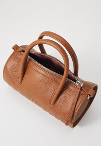 Taschenhandtasche aus braunem Leder mit strukturierter Oberfläche, doppelten abgerundeten Griffen, Reißverschluss und Innenfutter in kontrastierendem Burgunderrot. Runder Boden.