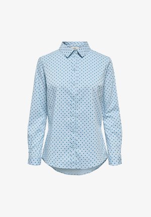 Světle modrá košile na knoflíky s dlouhými rukávy, která má vzor s puntíky v tmavě modré. Klasický límeček a zakřivený lem.