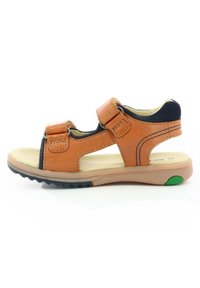 Sandalia de cuero marrón con dos correas ajustables, diseño de punta abierta, plantilla texturizada y suela de goma con un acento verde.