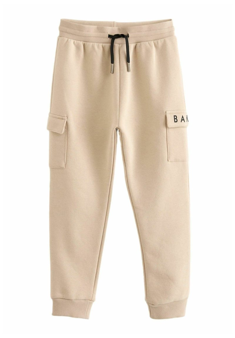 Pantalones de chándal beige hechos de una tela suave, con bolsillos laterales, una cintura con cordón y un parche con 'BAK' en el muslo derecho.