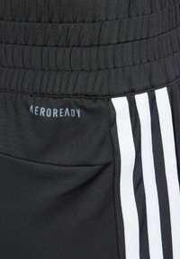 Pantalones deportivos negros con una cinturilla texturizada, rayas laterales blancas y el logo "AEROREADY" en gris claro. Tela suave y diseño ajustado.