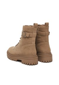 Brązowe zamszowe botki za kostkę z grubą gumową podeszwą, wiązaniem z przodu, bocznym detalem w postaci klamry oraz wzmocnionym tyłem dla lepszego wsparcia.