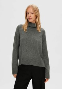 Dunkelgrauer Rollkragenpullover mit lockerer Passform, gerippten Bündchen und Saum. Weicher Strickstoff, verkürzte Länge und leicht überschnittene Schultern.