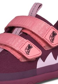 Chaussures à scratchs en violet foncé et rose, avec un tissu texturé, des accents blancs triangulaires et un logo décoratif sur les brides.