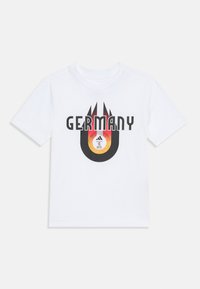 Camiseta blanca de algodón con un estampado gráfico que presenta "ALEMANIA" en colores negro y rojo en negrita, acompañado de un emblema circular en el centro.