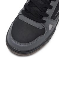 Czarno-szare buty sportowe z gładkim skórzanym noskiem, teksturowanym siateczkowym wierzchem, solidnymi sznurówkami i trwałą gumową podeszwą.