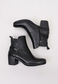 Bottines en cuir noir avec un talon carré, fermeture éclair sur le côté et sangle décorative. Texture lisse avec un éclat subtil, semelle en caoutchouc robuste.
