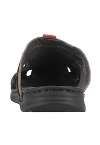 Black leather sandal with an open back, beige stitching, and a red accent tab. Features a textured sole and ventilation holes for breathability.