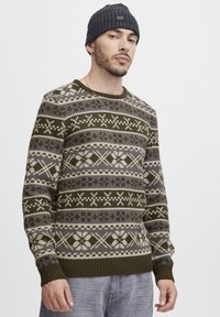 Grüner, gemusterter Strickpullover mit Schneeflocken- und Quadratmuster in Beige und Grau, mit gerippten Bündchen, Rundhalsausschnitt und weicher Textur.