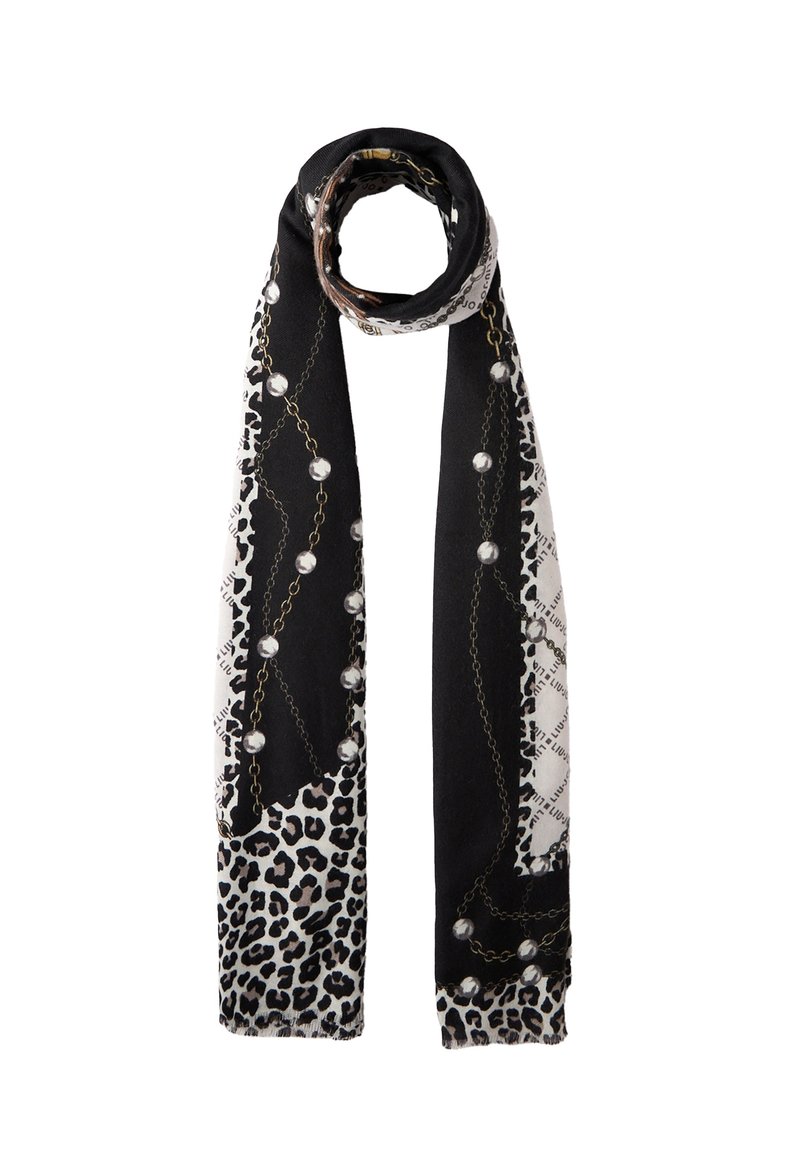 Écharpe longue noir et blanc avec un motif léopard, des chaînes et des perles, soigneusement enroulée à une extrémité sur un fond uni.