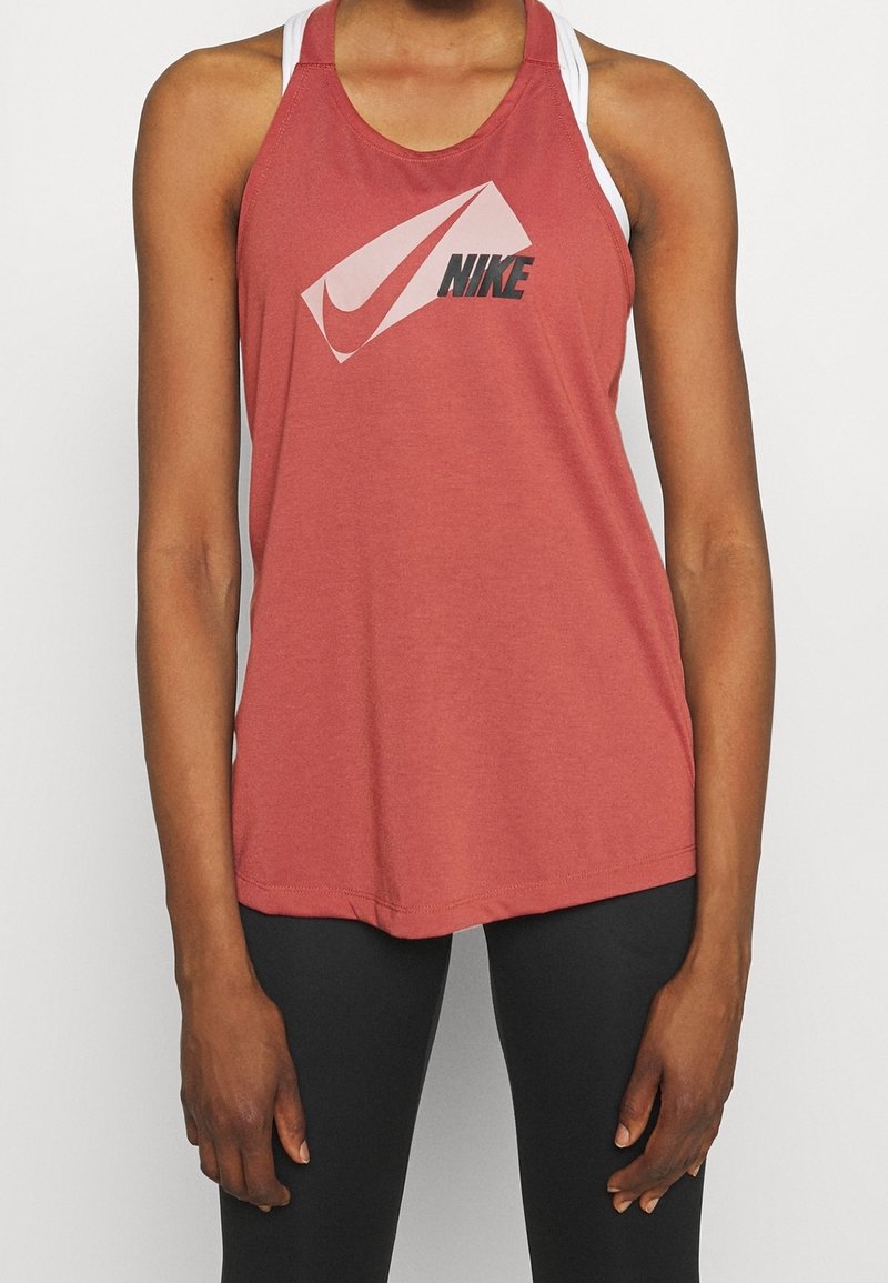 Punainen urheilullinen toppi, jossa on pyöreä pääntie ja suuri valkoinen ja musta Nike-logo. Valmistettu pehmeästä, kevyestä kankaasta.