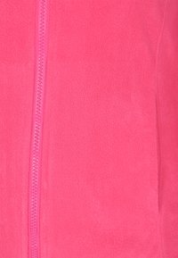 Giacca in pile con zip di un brillante colore rosa, caratterizzata da una texture liscia, zip totale e cuciture piatte ai lati.
