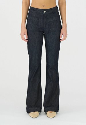 Jeans svasati blu scuro con due tasche frontali, una chiusura a bottoni e una texture liscia. Presenta cuciture a contrasto e leggere sfumature.