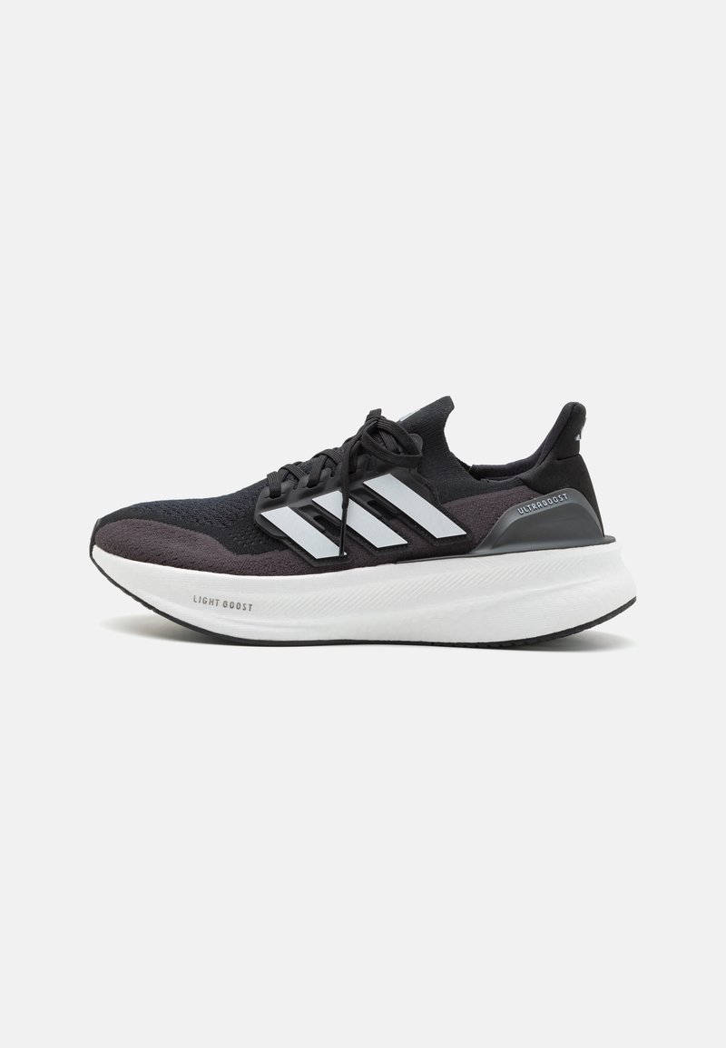 Black and gray athletic shoes with a mesh upper, three white stripes, and a thick, white, cushioned sole labeled "LIGHT BOOST."