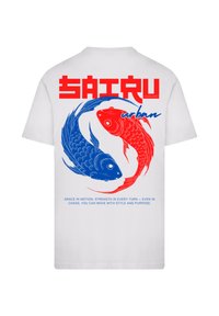 Weißes T-Shirt mit roten und blauen grafischen Illustrationen von Koi-Fischen, mit fettem Schriftzug und Text auf dem Rücken. Lässige Passform.