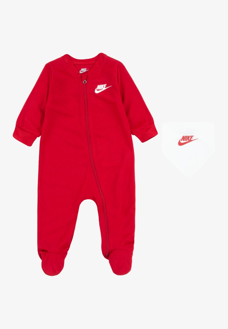 Piros pamut overall hosszú ujjakkal és talpbetéttel; elöl cipzárral és Nike logóval rendelkezik. Tartalmaz egy illeszkedő fehér sálat logóval.