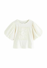 Haut à manches courtes de couleur crème avec un panneau carré brodé présentant des motifs floraux, des manches bouffantes et un col rond.