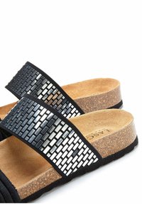 Zwarte slippers met een spiegeldessineerband, kurken voetbed en textuur rubberen zool. Platter ontwerp met elastische accenten voor comfort.