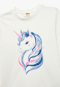 Weißes T-Shirt mit einem bunten Einhorn-Design, das eine fließende Mähne in Blau, Pink und Lila zeigt, versehen mit einem spiralförmigen Horn und sanften Gesichtszügen.