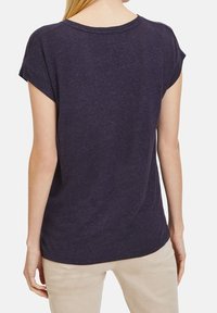 Námornické tričko s krátkým rukávem a volným střihem, s kulatým výstřihem a jemnou strukturou. Zadní pohled ukazuje minimální švy a ležérní design.