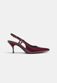 Pump slingback in pelle verniciata bordeaux con punta affilata, tacco sottile e design a taglio; dotato di una tracolla regolabile con fibbia.