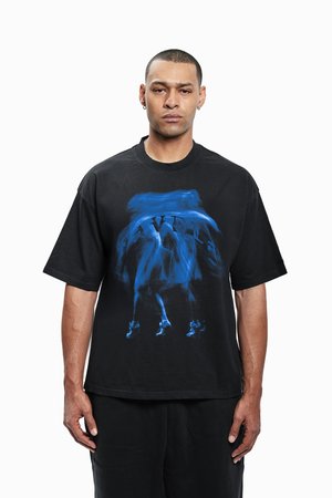 Camiseta negra de gran tamaño hecha de algodón, con un diseño gráfico abstracto azul en la parte frontal. Corte holgado con mangas cortas y cuello redondo.