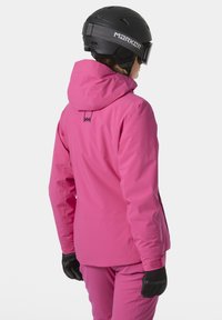 Rosa wasserdichte Skijacke mit Kapuze, featuring einer glatten Textur, subtiler Markenkennzeichnung und schwarzen Handschuhen, von hinten betrachtet.
