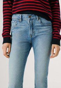 Hea sinine denim teksad kitsase lõikega, viis taskut, kuldse tooni metalldetailid ja kerged hõõrdumise detailid kangal.