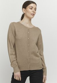 Beige knitted cardigan featuring a round neckline, button closure, long sleeves, and ribbed cuffs and hem. Fabric appears soft and smooth.