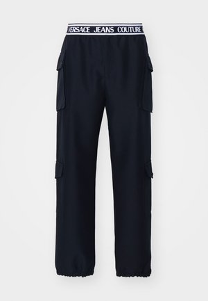 Schwarze Cargo-Hosen mit elastischem Bund und einem weißen Logo. Seitentaschen und elastische Bündchen an den Knöcheln. Aus strapazierfähigem Stoff gefertigt.