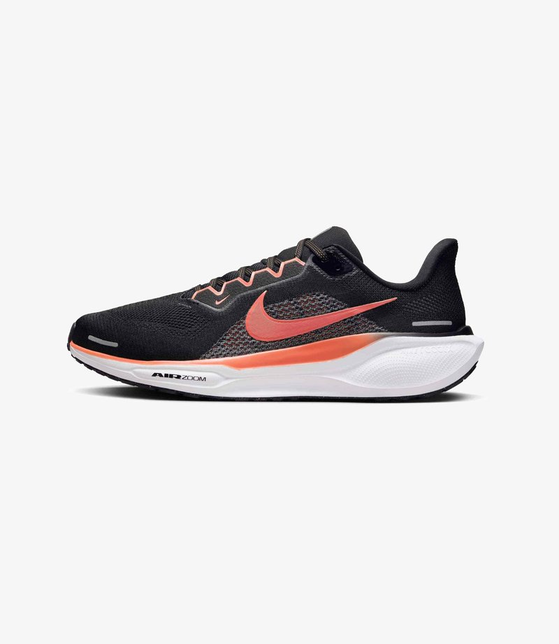 Scarpa da corsa Nike con tomaia in rete nera, accenti corallo e suola intermedia bianca. Presenta una punta arrotondata, design con lacci e marchio Air Zoom visibile.