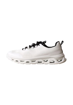 Baskets blanches de sport avec lacets noirs, doublure intérieure noire, dessus en mesh respirant et semelle épaisse avec découpe géométrique.