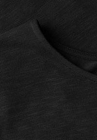 Top nero a maniche corte con una texture liscia e un collo rotondo rifinito con dettagli a costine, che mostra leggere variazioni nel tono del tessuto.